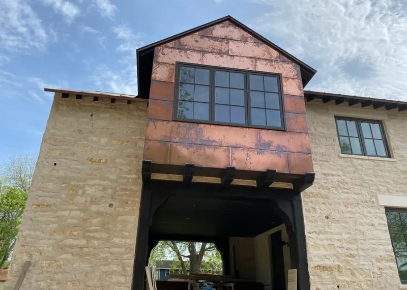 Copper metal panel facade on a stone building for Roof Repair in Houston