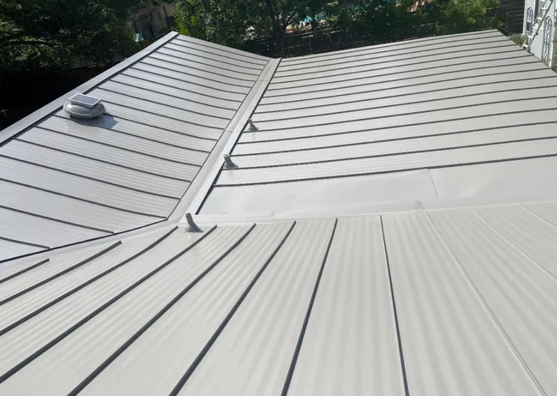 Solar attic fan installed on a metal roof for Roof Ventilation in Houston